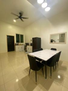 Una mesa de comedor con sillas y un ventilador de techo. en HOUSE 30 Paddy View 3509 sqft Private Yard HSB, en Alor Setar
