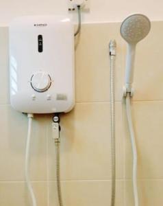 a shower head and a hair dryer on a wall at HOUSE 30 Paddy View 3509 sqft Private Yard HSB in Alor Setar +34 photos