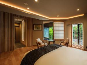 a bedroom with a large bed with chairs and a table at Hakone Hibarino in Hakone