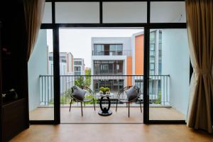 a room with a balcony with a table and chairs at Paradise Bay Hotel - Vinhomes Ocean Park 3 in Ðình Loan