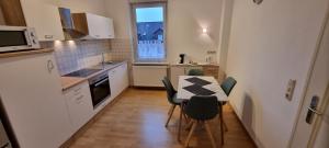 a small kitchen with a table and chairs in it at Charmante, ruhige Erdgeschosswohnung mit Balkon in Lüdenscheid
