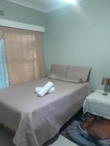 a bedroom with a bed with two white towels on it at Uptown Inn GuestHouse in Parys