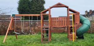 a playground with a swing set and a play structure at 5 bedrooms, sleeps up to 16, secure parking space & comfort in Skegby