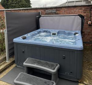 a large jacuzzi tub in a backyard at 5 bedrooms, sleeps up to 16, secure parking space & comfort in Skegby