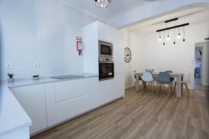 une cuisine avec des placards blancs et une salle à manger avec une table dans l'établissement MY DREAM, à Alcains