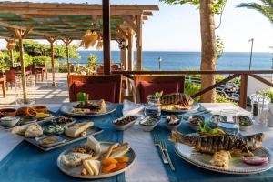 Anadolu Hotels Didim Club في ديديم: طاولة مع أطباق من الطعام على قطعة قماش من الطاولة الزرقاء