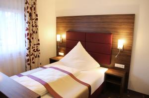 una camera con letto e testata in legno di Hotel Rothkamp a Frechen