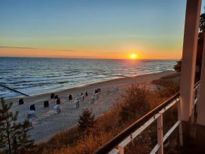 a sunset on a beach with a group of people at Bungalow Mika und Lizzy in Ostseebad Koserow
