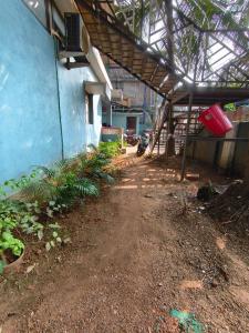 カナコナにあるThyme Guests Houseの建物の隣に未舗装道路がある建物