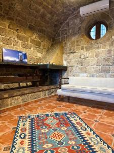 Habitación con banco y pared de piedra. en Bab El Mina guest house Byblos, en Biblos