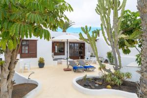 un cortile con palme e una casa di Puerto Chico C a Playa Blanca