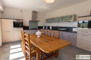 a kitchen with a wooden table and some cabinets at Gîte de la cascade in Le Mas Haut +17 photos
