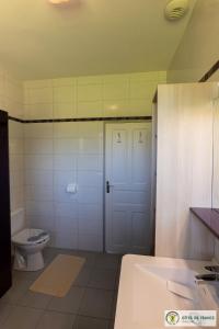 a bathroom with a toilet and a white door at Gîte de la cascade in Le Mas Haut +28 photos