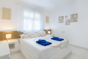 una camera da letto bianca con un letto bianco con asciugamani blu sopra di Puerto Chico C a Playa Blanca