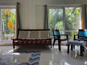 a living room with two chairs and a couch at Murthi's Farm House in Coimbatore