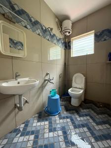 a bathroom with a sink and a toilet at Murthi's Farm House in Coimbatore +7 photos