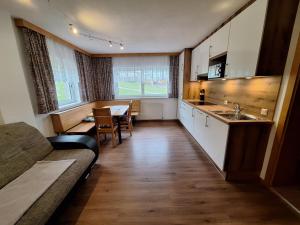 eine Küche und ein Esszimmer mit einem Sofa und einem Tisch in der Unterkunft Appartements Rosmarie in Fendels
