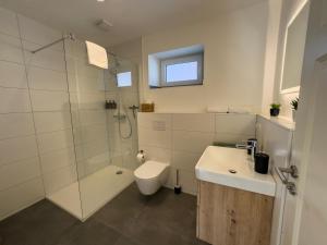 a bathroom with a shower and a toilet and a sink at Charmantes Winzerhaus mit privatem Hof nahe der Weinberge - Pfalz in Großfischlingen +11 photos