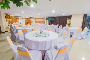 un salón de banquetes con mesas blancas y sillas blancas en Three Seasons Place, en Bangkok