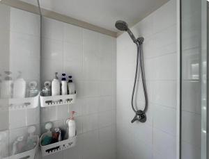 een douche in een wit betegelde badkamer met een douchekop bij UQ single bedroom with pool Q2 in Brisbane +23 foto's