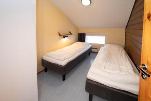 a room with two beds and a window at Ski Center Alpine Houses B4 in Kittilä