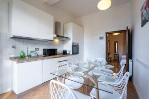 a kitchen with a table and white chairs in a room at Firenze Center - 9' to Duomo & Uffizi - AC, Wifi in Florence