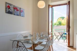 a dining room with a glass table and white chairs at Firenze Center - 9' to Duomo & Uffizi - AC, Wifi in Florence +19 photos