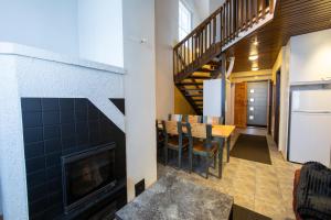 a living room with a fireplace and a dining room at Ski Center Alpine Houses B4 in Kittilä