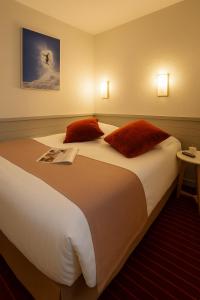 a large bed in a hotel room with red pillows at Résidence La Daille - Val-d'Isère in Val dʼIsère