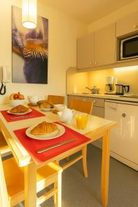 a kitchen with a table with plates of food on it at Résidence La Daille - Val-d'Isère in Val dʼIsère