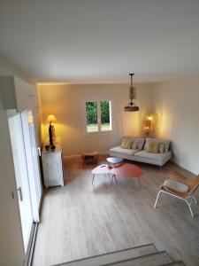 een woonkamer met een witte bank en een tafel bij École des fans in Narrosse