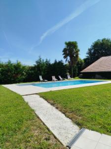 een zwembad met twee ligstoelen ernaast bij École des fans in Narrosse