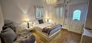 Un dormitorio con una cama y un sofá y una ventana. en Santorini Studios Pleasure, en Perissa