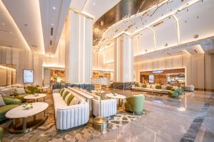 a hotel lobby with couches and tables at Grande Centre Point Prestige Bangkok in Bangkok