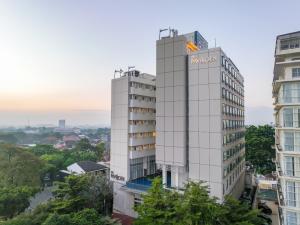 a tall white building with a sign on it at De Paviljoen Bandung in Bandung