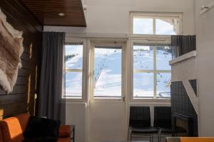 a room with a view of a ski slope through windows at Ski Center Alpine Houses B4 in Kittilä