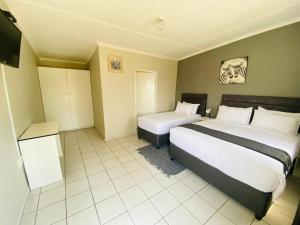 a hotel room with two beds and a tv at Phola La Bed and Breakfast in Melmoth
