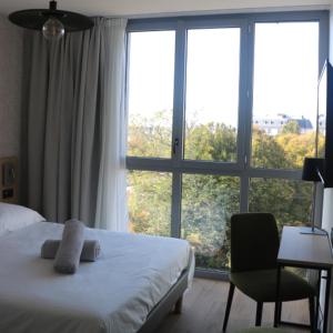 une chambre avec un lit et une grande fenêtre dans l'établissement Abalys Hotel, à Brest
