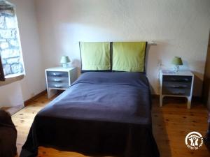 a bedroom with a large bed with two night stands at Gîte de Myriam aux portes des Gorges du Tarn in Rivière-sur-Tarn