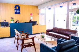 a lobby of an office with a couch and chairs at MLG Hotel in Mogi das Cruzes