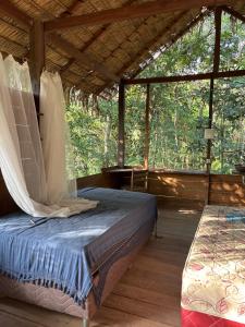 a bed in a wooden room with a large window at Campo de Heliantos in Santarém