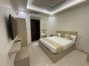 een slaapkamer met een bed en een televisie. bij Hotel Crown Plaza in Prayagraj +39 foto's