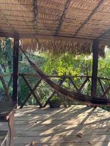 a hammock on a porch with a thatched roof at Campo de Heliantos in Santarém +12 photos