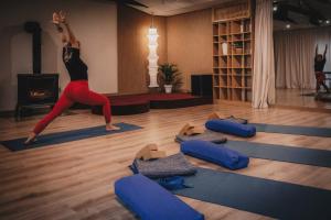 una mujer haciendo una pose de yoga en una clase de yoga en Półwysep Zacisze - Tiny House Village, en Przywidz