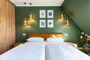 a bedroom with a white bed with green walls at Sommerfrische in Ahrenshoop
