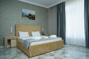 een slaapkamer met een groot bed met handdoeken erop bij Kolizey Hotel Spa Ganja in Ganja