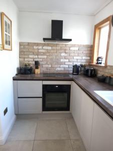 a kitchen with a counter top with a microwave at Small cottage in Stratton, Bude in Stratton +5 photos