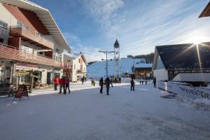 a group of people walking around in a street at Ski Center Alpine Houses A6 in Levi