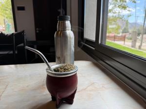 a container of seeds and a bottle on a table at Cabañas boutique Huella Andina in Potrerillos