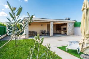 a patio with a table and chairs in front of a house at Villa Deluxe Buna in Mostar